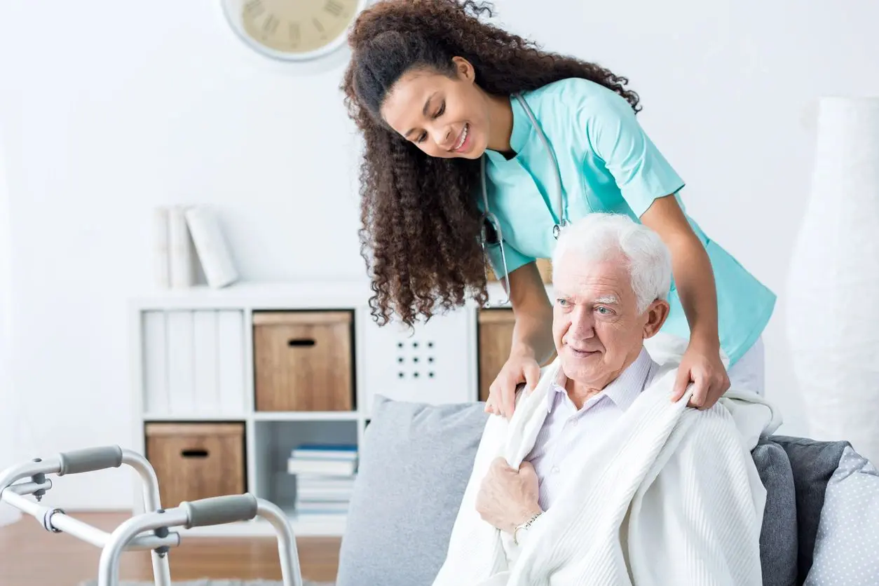 A woman helping an older man to get up.